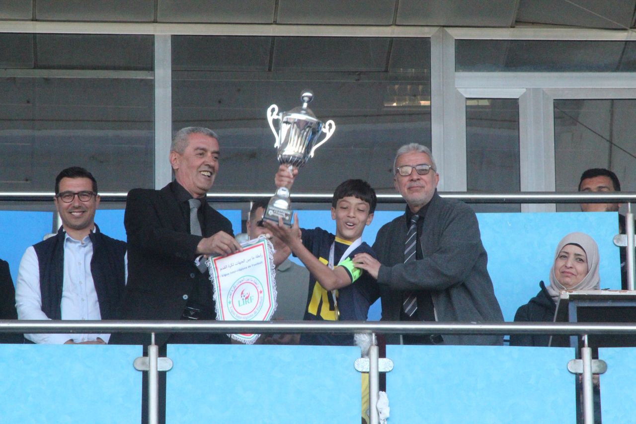 رئيس رابطة ما بين الجهات عز الدين بن محمد يسلم كأس الطبعة الثانية للدورة الوطنية لاكاديميات كرة القدم أقل من 13 سنة لقائد النادي المتوج اتلتيك بارادو